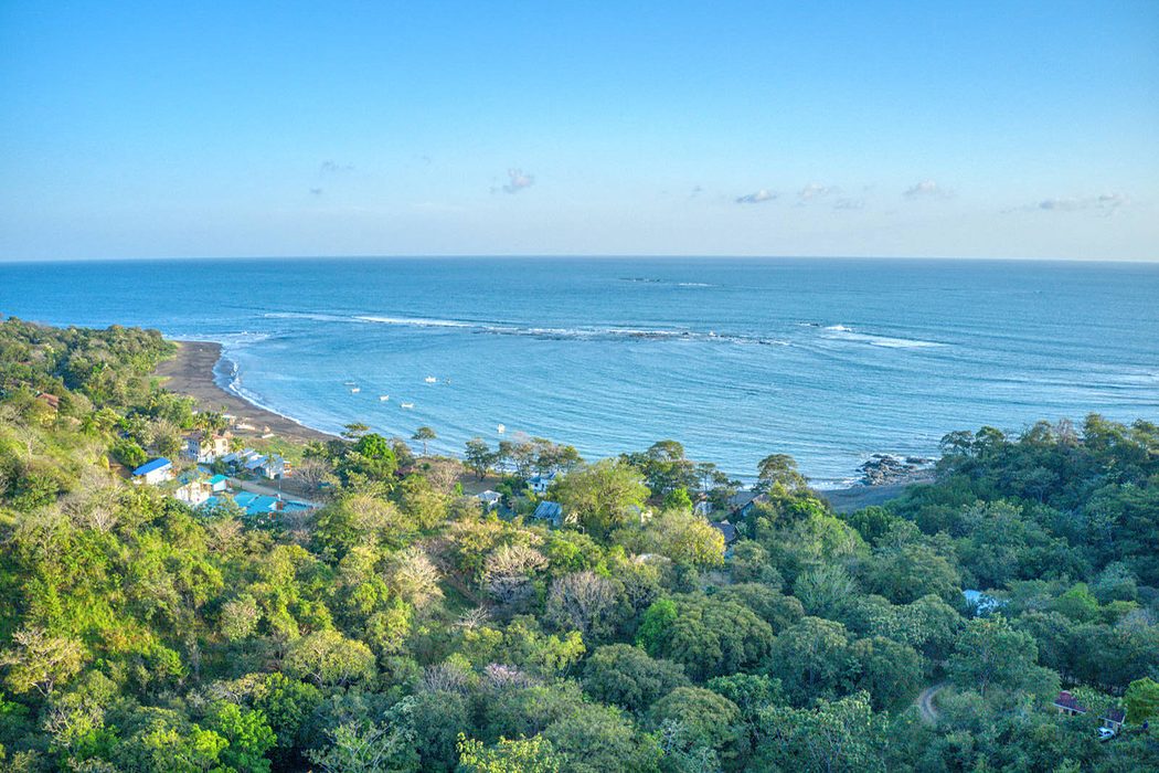 Homesites grouped tightly within preserved forest canopy above the Cambutal coastline, the cluster development model Eagle Properties uses to protect Parque Los Buzos
